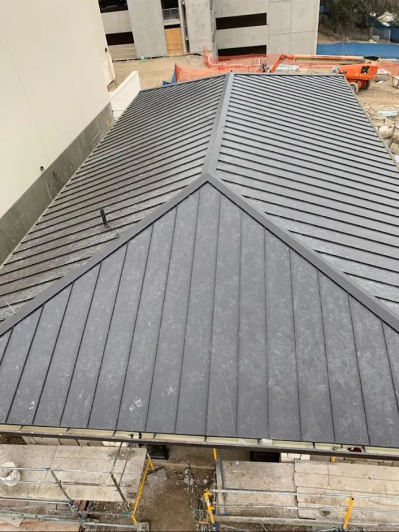 Commercial metal roof construction with crane equipment in East Bakersfield